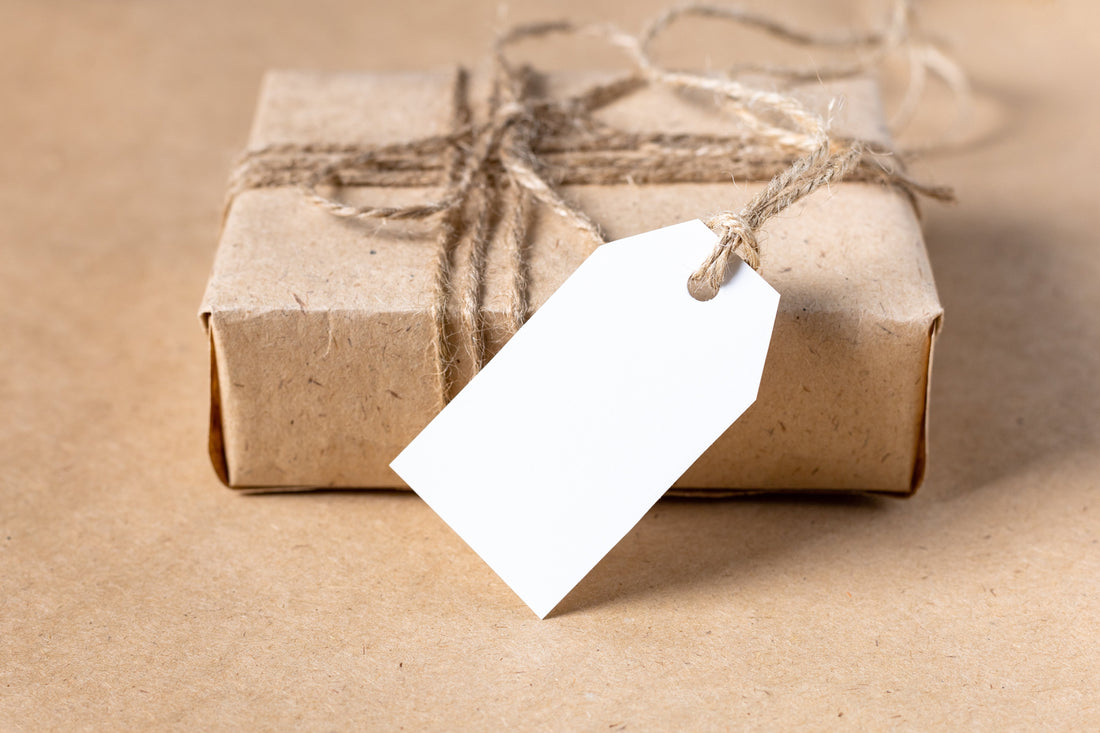 Liebevoll mit Kraftpapier verpacktes Geschenk mit leerem Anhänger – Geldgeschenk originell verpacken